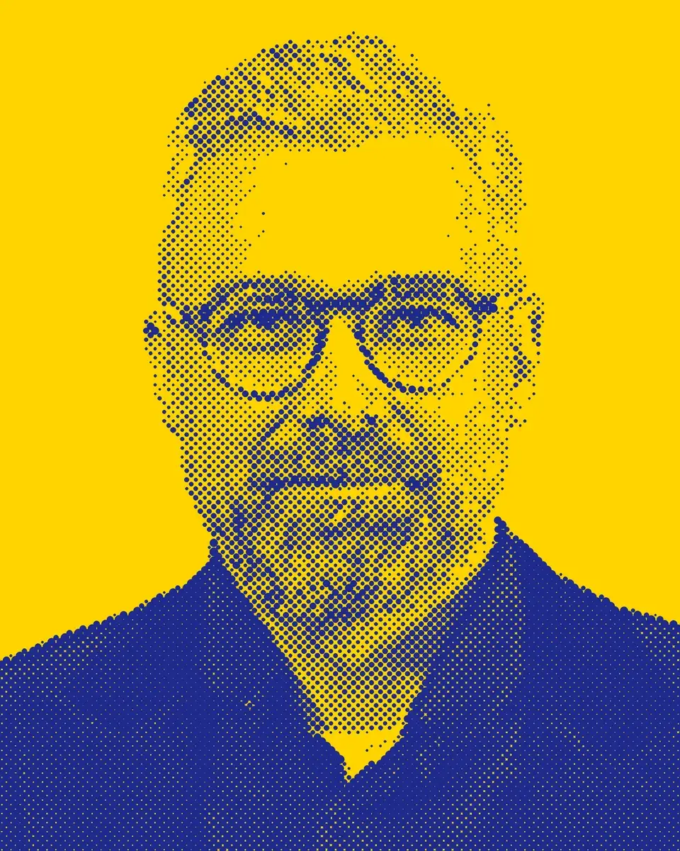 Georg Zawadzki als Rasterbild aus blauen Punkten auf gelbem Grund: kurze Haare, runde Brille, Bart, dunkles Sakko
